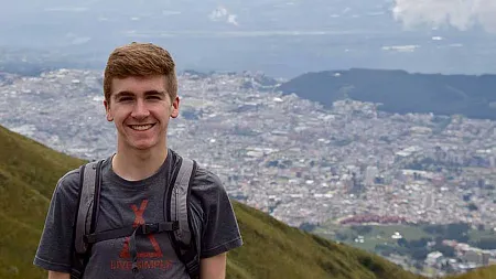 student on a hillside overlooking a view of a city