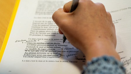 closeup of student writing in a French language workbook