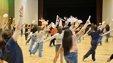students practice a traditional Chinese fan dance during foreign language and international studies day