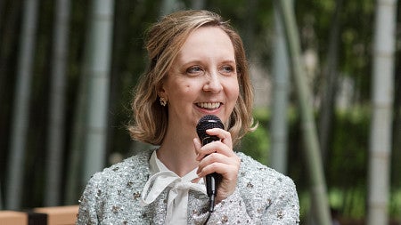 woman smiling and holding a microphone