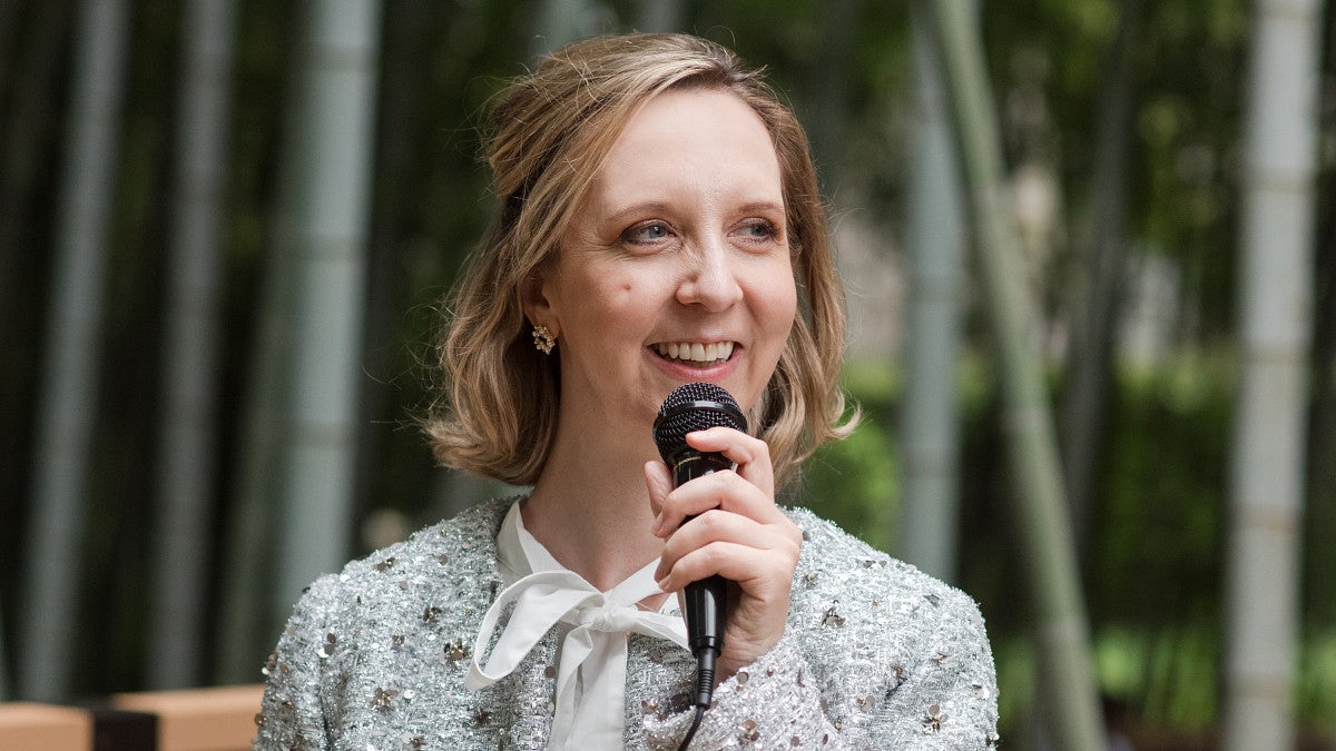 woman smiling and holding a microphone