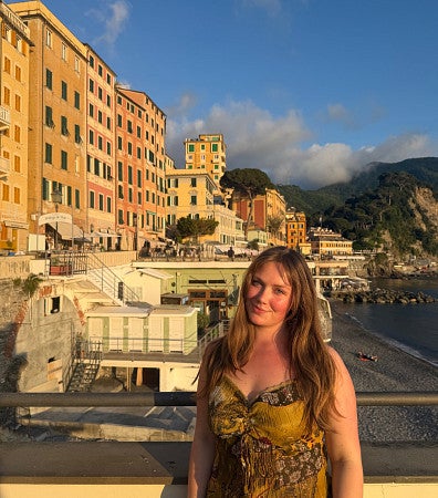 woman standing in front coast and buildings in northern italy