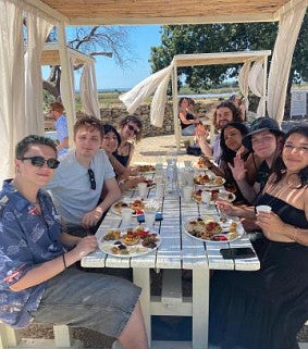group of students eating at a table outside in Italy