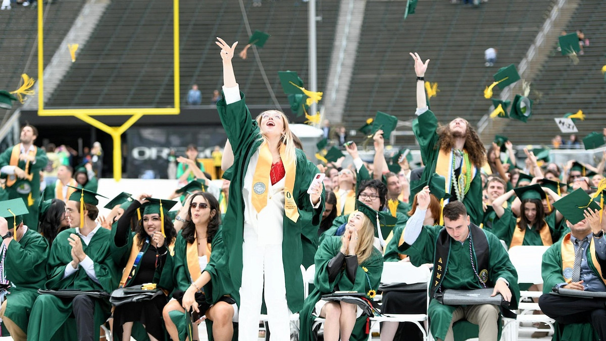 Graduates throwing hats in UO 2023 commencement